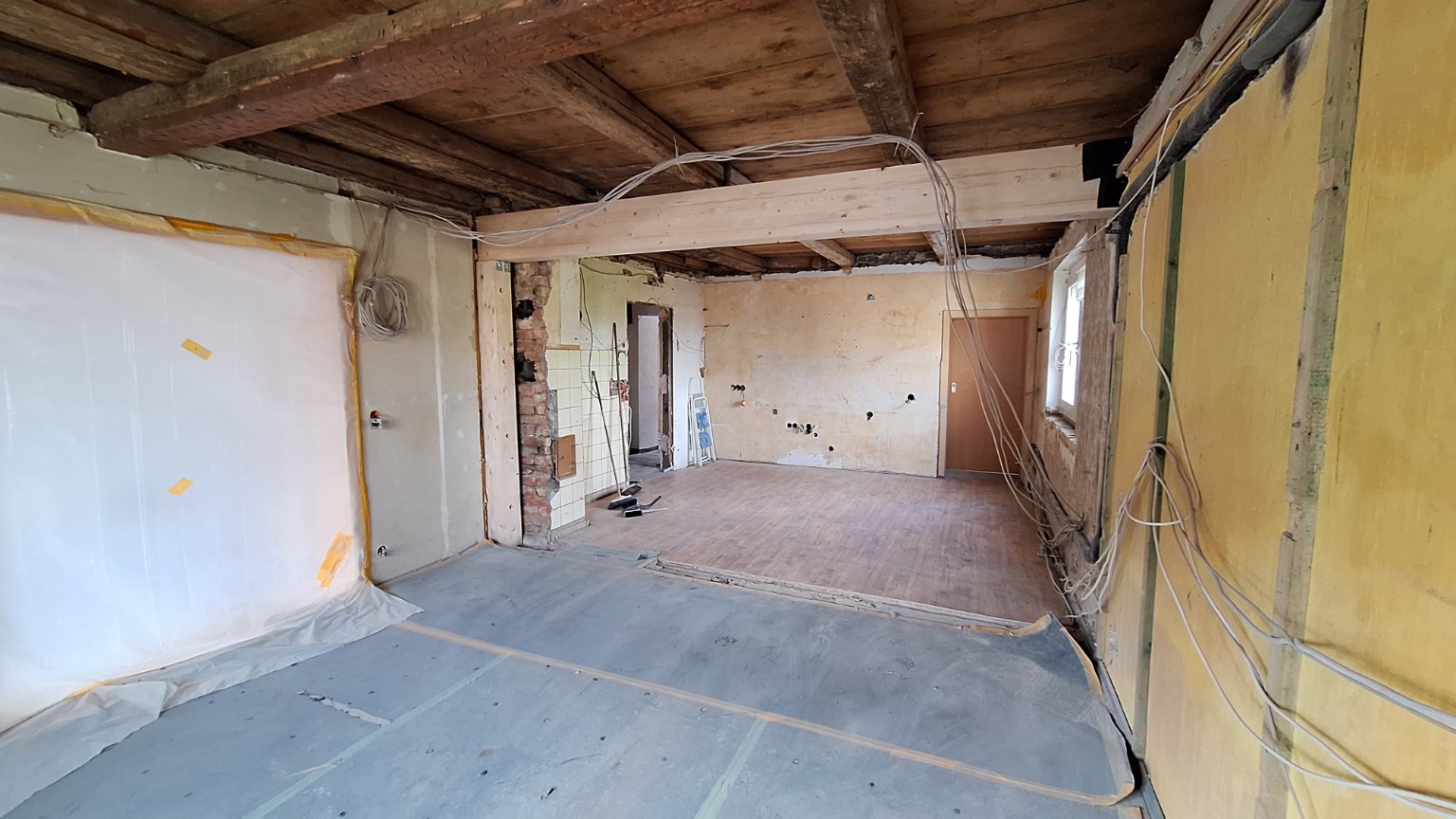 Großer Innenraum vor der Renovierung mit offener Holzdecke